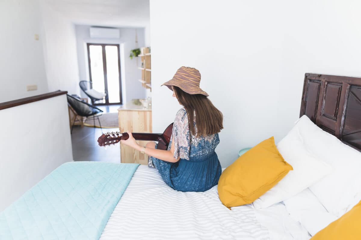rear-view-woman-sitting-bed-playing-guitar ΠΑΚΕΤΟ 1 - ESSENTIAL - Image 1